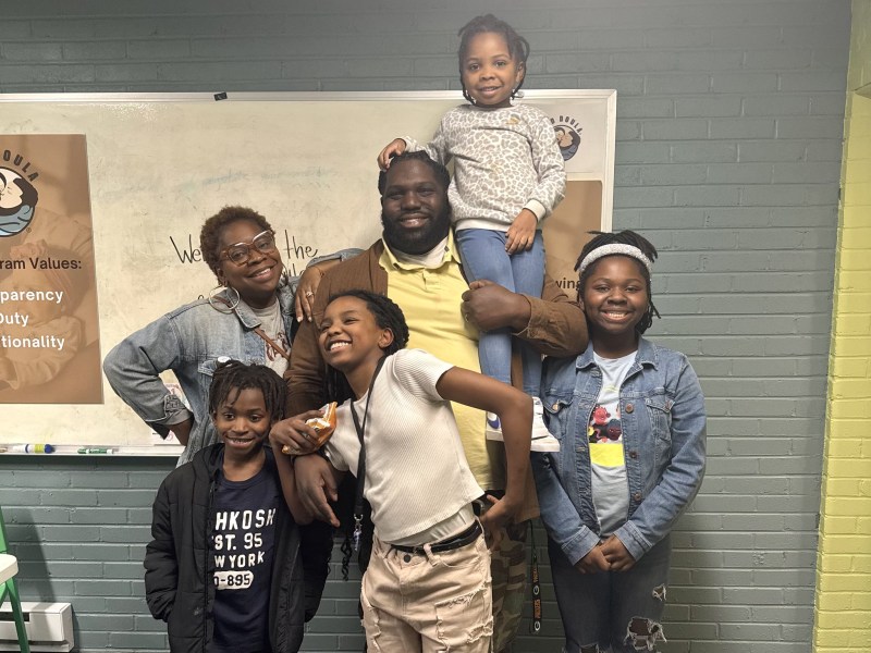 Woman and man pose and smile with their children