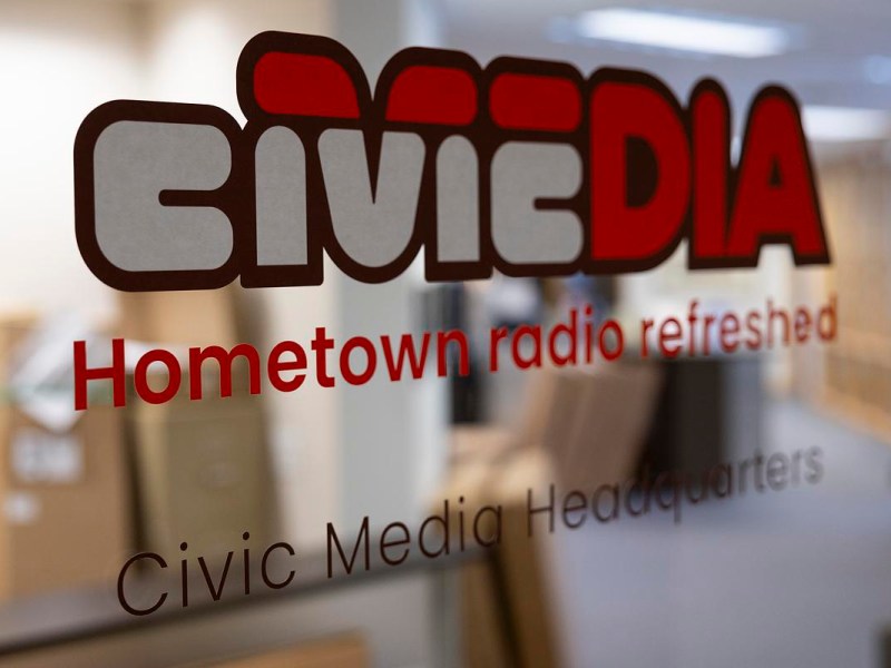 Glass door displays the logo and text "Civic Media" and "Hometown radio refreshed" with an office and cardboard boxes visible through the glass.