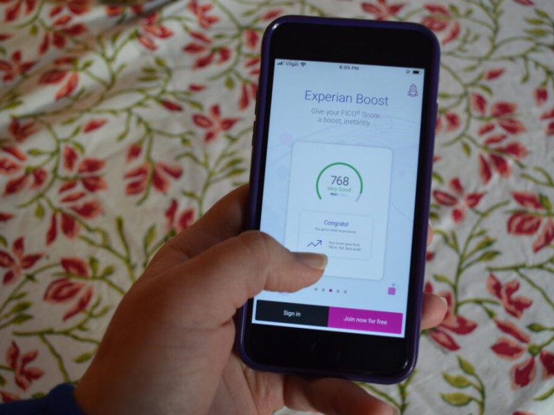 Hand holds phone with screen that says "Experian Boost"