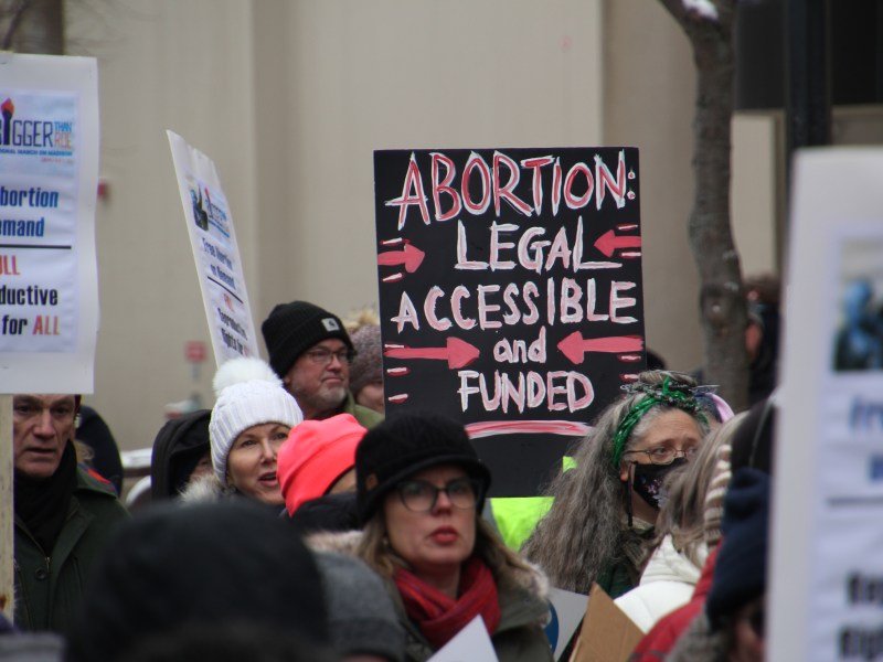 People hold signs advocating for legal abortion.