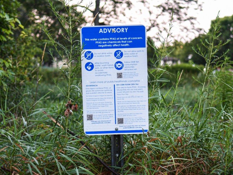 Advisory sign in front of greenery
